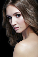 Female with wavy hair on black background.