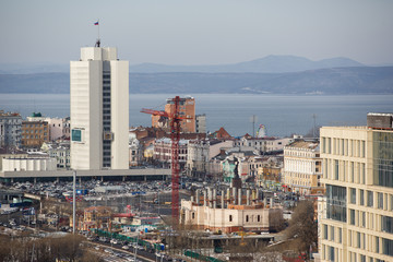 2013 - Sea facade in the capital of the Far East, the city of Vladivostok. Sea trading port with ships. Drifting ships in the raid.	