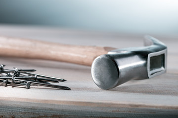 Hammer and steel nails in workshop, close up. Workshop background.