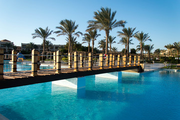 Fototapeta na wymiar Swimming pool and palm trees in luxury hotel 