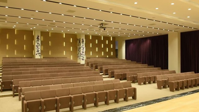 Light switched on/off, in empty conference hall with rows of seats for spectators and audience. Big empty modern meeting,seminar,conference room