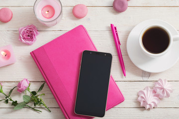 notebook with cup of coffee on white wooden table
