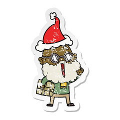 distressed sticker cartoon of a joyful man with beard and parcel under arm wearing santa hat