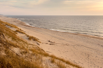 Fototapeta na wymiar Beautiful sunset seascape with sand beach in evening.