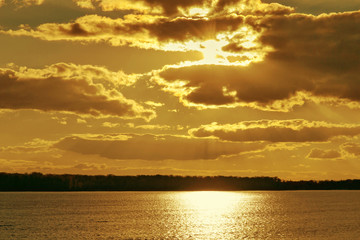 Fototapeta premium Beautiful clouds autumn sunset view over the river.