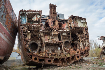 Huge rusty pieces of decommissioned marine ship that was cut and left on the shore.