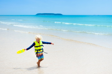 Child on tropical beach. Sea vacation with kids.