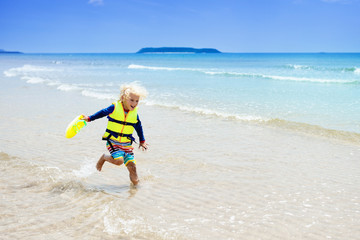 Child on tropical beach. Sea vacation with kids.