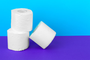 Toilet paper rolls isolated on white table with purple background