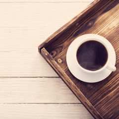 cup of coffee on tray on wooden table