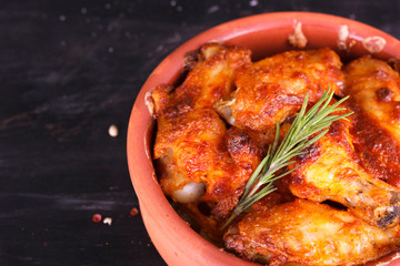 Chicken in paprika sauce baked in the oven in pottery. Chicken legs and wings