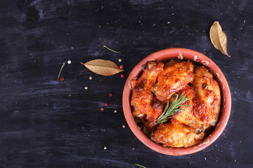 Chicken in paprika sauce baked in the oven in pottery. Chicken legs and wings