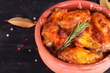 Chicken in paprika sauce baked in the oven in pottery. Chicken legs and wings