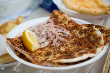 Baked turkish pizza with beef and cheese served outside