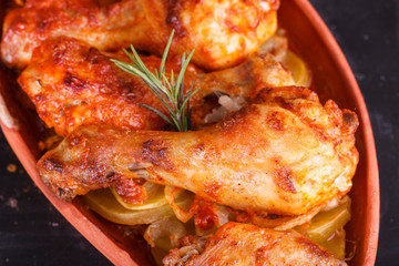 Chicken in paprika sauce baked in the oven in pottery. Chicken legs and wings
