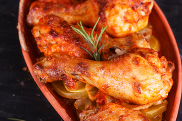 Chicken in paprika sauce baked in the oven in pottery. Chicken legs and wings