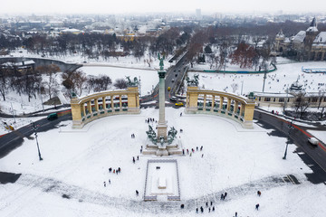 Obraz premium Budapest, Hungary - Snowy Heroes' Square and Millennium Monument from above on a cold winter day with City Park (Varosliget), Szechenyi Thermal Bath, Vajdahunyad Castle and ice rink at background