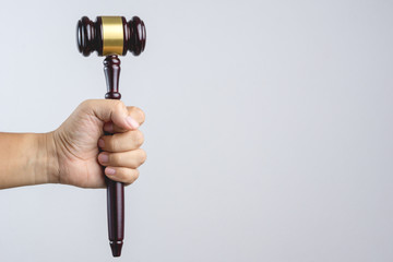 Hand holding wooden judge's gavel as a law or justice sign