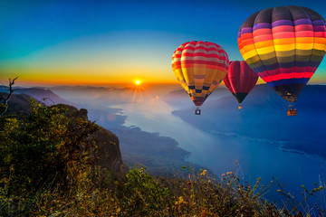 Colorful hot air balloons flying in sunrise over mountain and Ping River at Pha Daeng Luang, Mae...