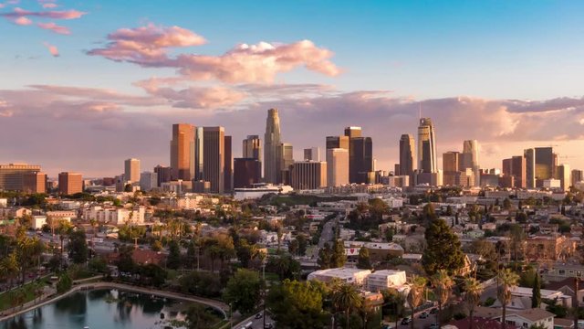 Aerial time lapse in motion or hyperlapse over Echo Park of downtown Los Angeles, California skyline and skyscrapers from above on a sunny day during golden hour before sunset.