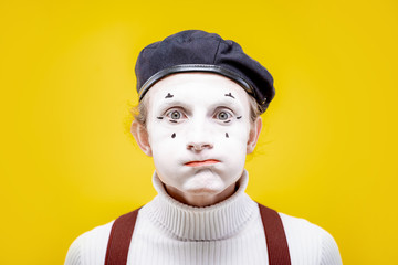 Portrait of an actor as a pantomime with white facial makeup showing expressive emotions on the...