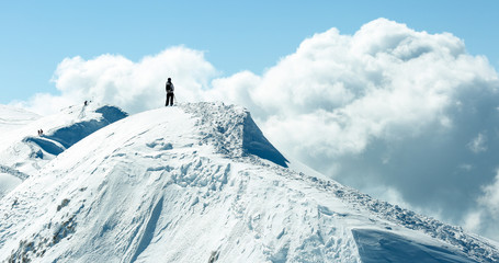 Fototapeta na wymiar Person standing on a snowy mountain peak