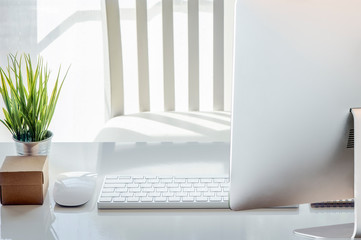 Fototapeta premium mouse, blank note, pencil, white keyboard,eyeglasses and houseplant on white table