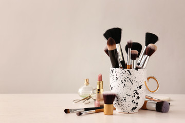 Set of makeup brushes and cosmetics on table - Powered by Adobe