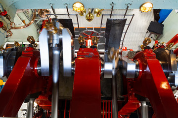 View into the red painted machine room of a vintage paddle steamer