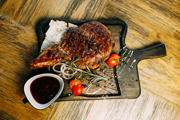 Well-done steak with suace. Reastaurant dishes on the wooden table. Food photo for restaurant menu. 