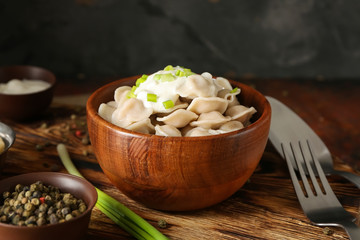 Bowl with tasty dumplings on table