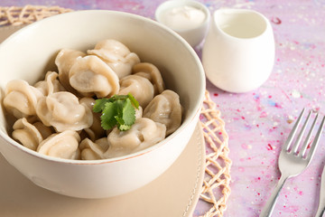 Bowl with tasty dumplings on table, closeup