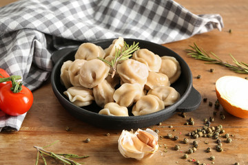 Pan with tasty dumplings on table