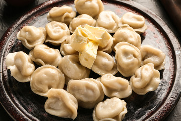 Board with tasty dumplings on table, closeup