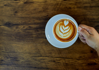 Hand Holding Coffee Cup On Table