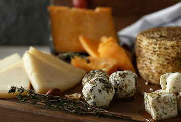 Assortment of tasty cheese on wooden board, closeup
