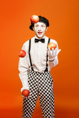 Portrait of an actor as a pantomime with white facial makeup showing expressive emotions on the...
