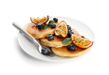 Tasty pancakes with passion fruit and berries on white background