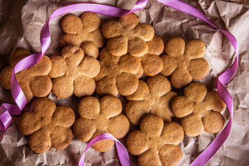 Gingerbread cookies in the shape of a flower lies in crumpled craft paper