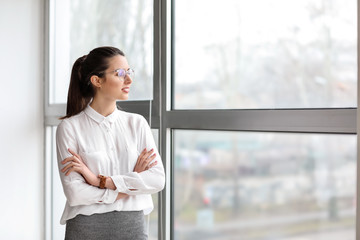 Portrait of young businesswoman near window in office