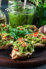 Bruschetta with fresh pesto, mozzarella and cherry tomatoes on cutting board