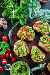 Bruschetta with fresh pesto, mozzarella and cherry tomatoes on cutting board