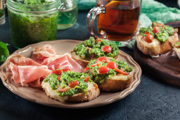 Bruschetta with fresh pesto, mozzarella and cherry tomatoes on a plate