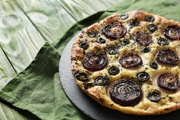Slate plate with tasty Italian focaccia on wooden table