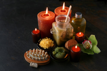 Obraz na płótnie Canvas Beautiful burning candles with cosmetic products on dark background
