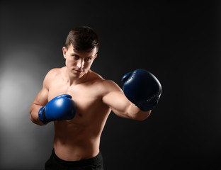 Attractive young boxer on dark background