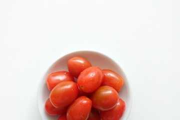 Tomato in white plate on white background. 