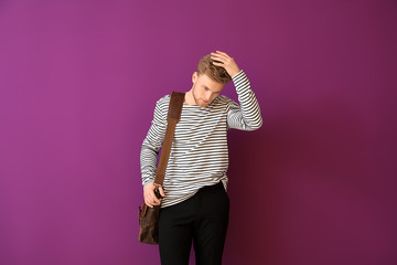 Handsome man with stylish briefcase on color background