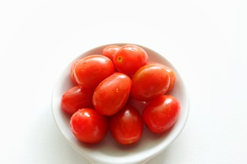 Tomato in white plate on white background. 