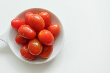 Tomato in white plate on white background. 